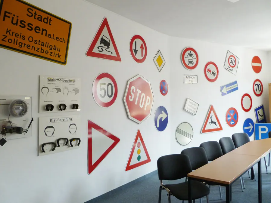 Wand mit Verkehrszeichen und Ortsschild Füssen im Unterrichtsraum von Andi's Fahrschule